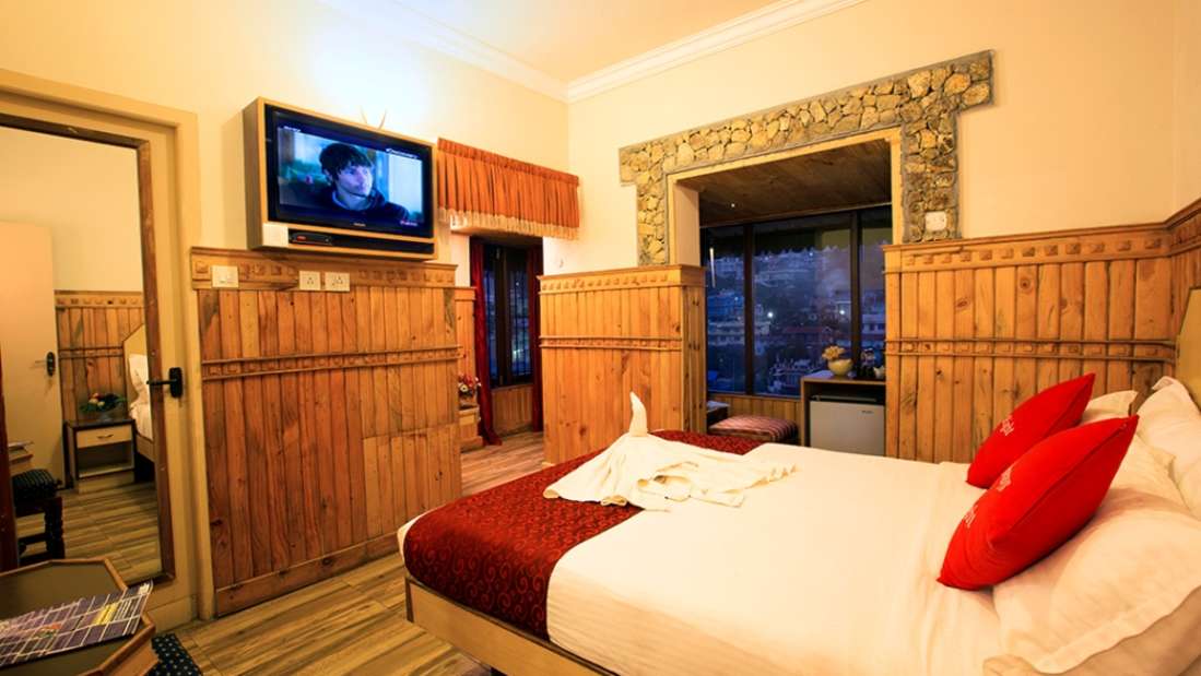 Wooden-style bedroom with TV and scenic view at Pine Borough Inn"