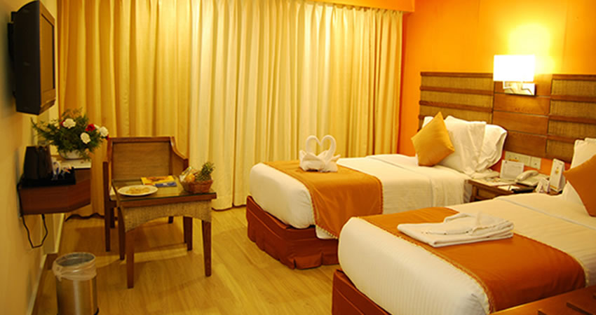 Double beds with TV and chairs at Sabari Resorts