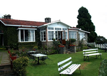 Exterior view of Villa Retreat featuring a lush garden and a cozy sitting chair